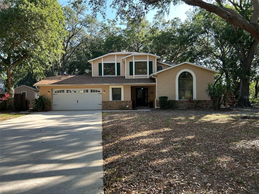 view of front of house with driveway, a garage, and stucco siding