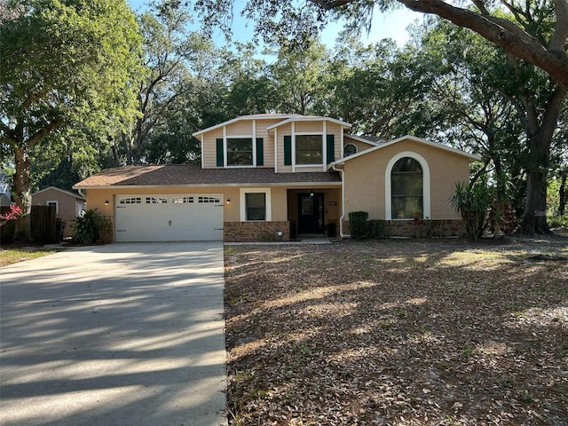view of front of house with driveway, a garage, and stucco siding