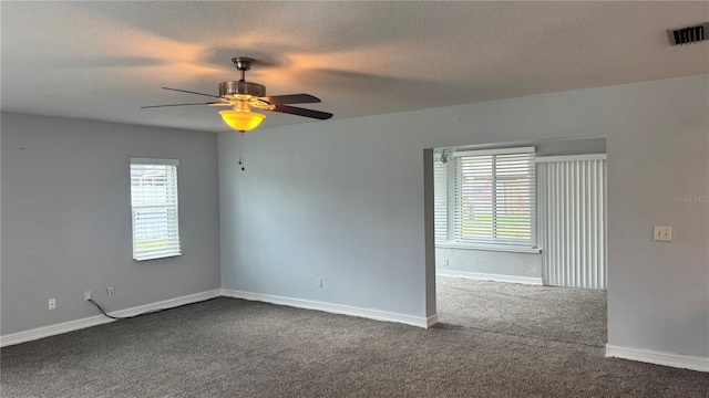 unfurnished room featuring a textured ceiling, visible vents, ceiling fan, baseboards, and dark carpet