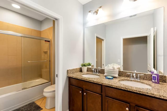 313 Captiva Dr, Davenport, FL 33896 - full bathroom with double vanity, toilet, tile patterned flooring, and combined bath / shower with glass door