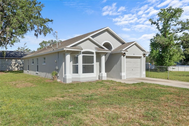 ranch-style home featuring fence, concrete driveway, a front yard, an attached garage, and stucco siding