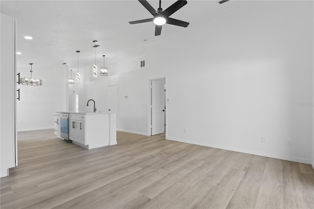 unfurnished living room featuring light wood-style floors, visible vents, baseboards, recessed lighting, and ceiling fan with notable chandelier