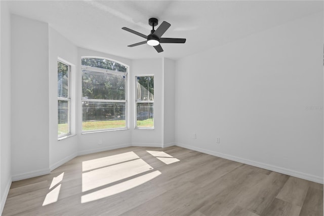 empty room featuring ceiling fan, baseboards, and light wood-type flooring