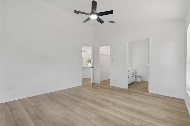 unfurnished bedroom featuring light wood finished floors, visible vents, a spacious closet, baseboards, and ensuite bathroom