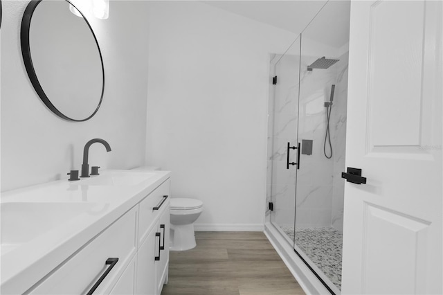 bathroom with toilet, a marble finish shower, vanity, and baseboards