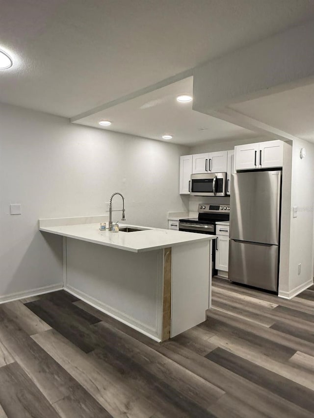 1799 N Highland Ave Unit 143, Clearwater, FL 33755 - kitchen featuring white cabinets, a sink, appliances with stainless steel finishes, baseboards, and a peninsula
