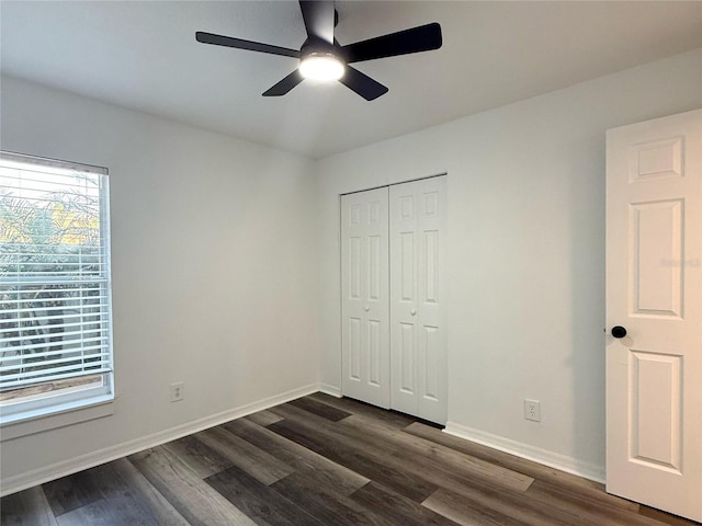 1799 N Highland Ave Unit 143, Clearwater, FL 33755 - unfurnished bedroom featuring dark wood finished floors, baseboards, ceiling fan, and a closet