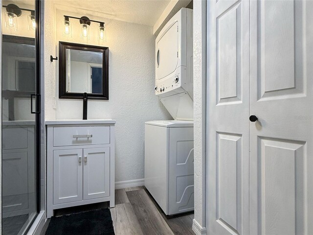 1799 N Highland Ave Unit 143, Clearwater, FL 33755 - washroom featuring stacked washer / drying machine, a sink, a textured wall, baseboards, and dark wood finished floors
