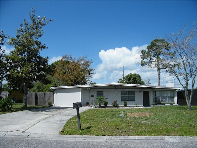 ranch-style house featuring a front yard, driveway, and fence