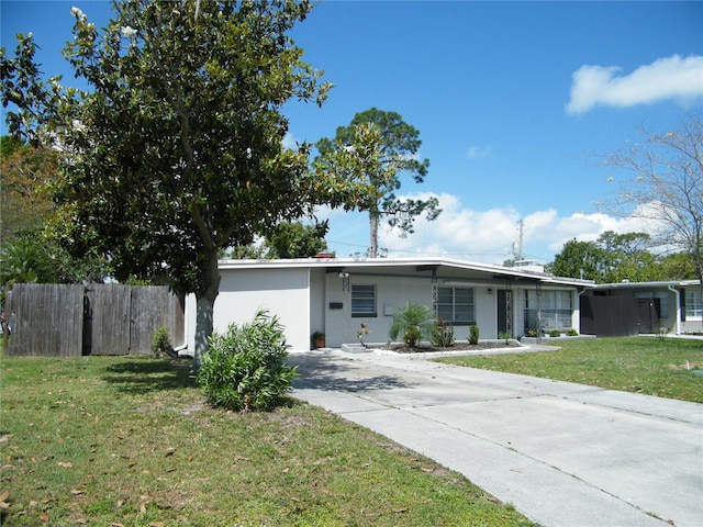 view of front of property featuring concrete driveway, a front yard, and fence
