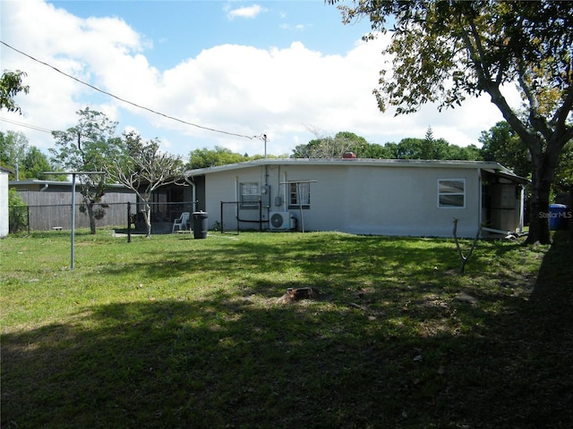 rear view of property with a yard and fence