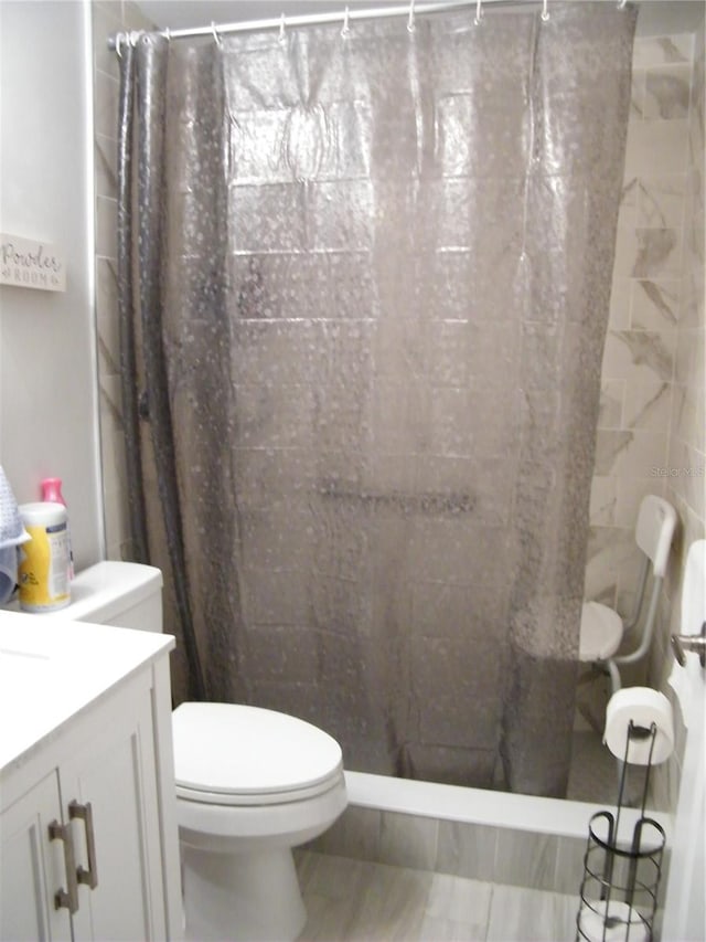 full bathroom with toilet, a stall shower, and vanity