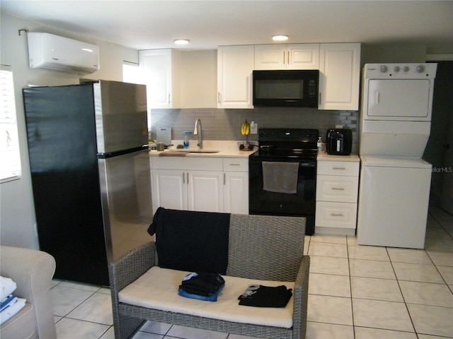 kitchen featuring stacked washer / drying machine, a sink, black appliances, an AC wall unit, and white cabinets