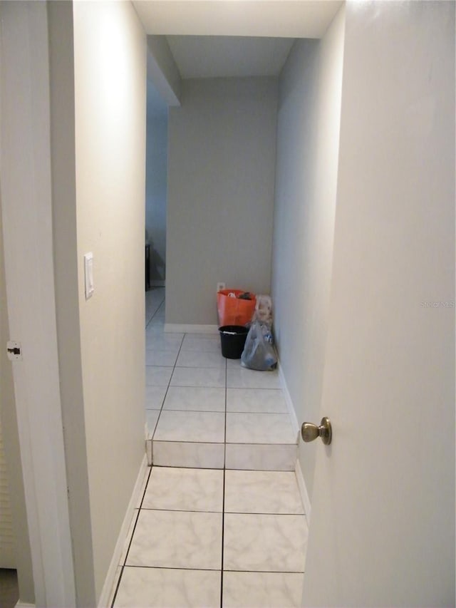 hallway featuring baseboards and light tile patterned floors