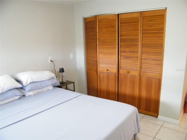 bedroom with light tile patterned flooring and a closet