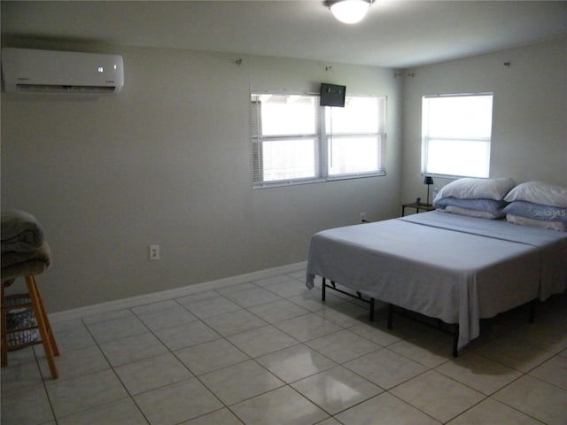 bedroom featuring light tile patterned flooring and an AC wall unit