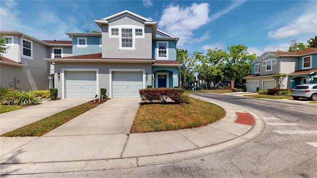 view of front facade featuring a residential view, concrete driveway, a garage, and stucco siding