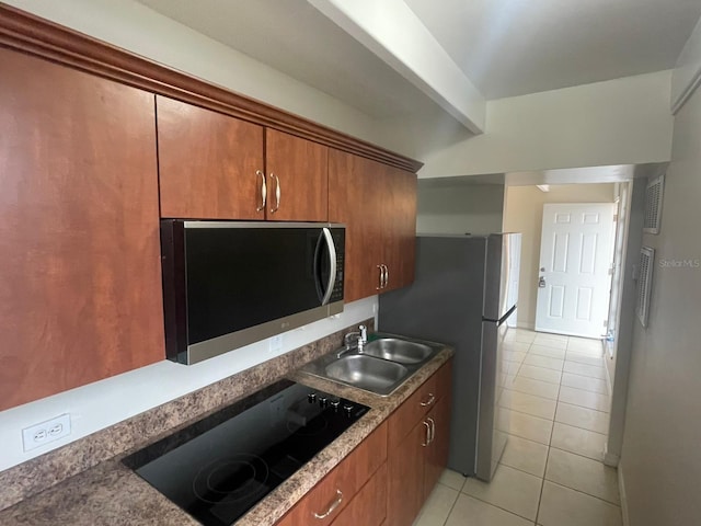 1837 Club Cir Unit 1837, Lakeshore, FL 33854 - kitchen with brown cabinetry, a sink, light tile patterned floors, beamed ceiling, and stainless steel appliances