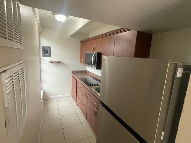 1837 Club Cir Unit 1837, Lakeshore, FL 33854 - kitchen featuring brown cabinets, a heating unit, stainless steel appliances, baseboards, and light tile patterned floors