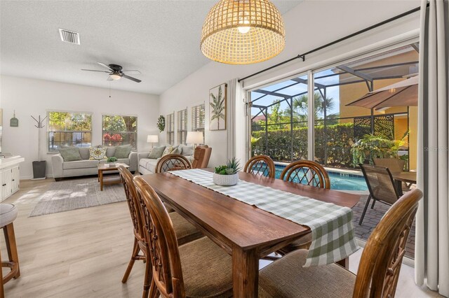 4722 Flagler Beach Way, Kissimmee, FL 34746 - dining space with light wood-style flooring, visible vents, a ceiling fan, a textured ceiling, and a sunroom