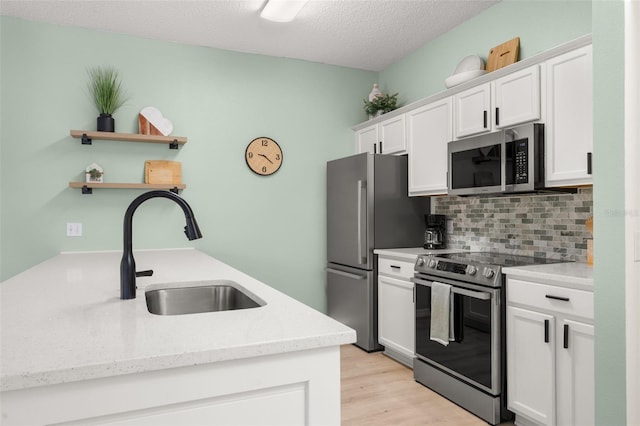 4722 Flagler Beach Way, Kissimmee, FL 34746 - kitchen featuring a sink, open shelves, stainless steel appliances, and white cabinetry
