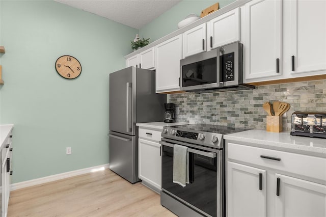 4722 Flagler Beach Way, Kissimmee, FL 34746 - kitchen featuring light wood-type flooring, white cabinets, stainless steel appliances, and tasteful backsplash