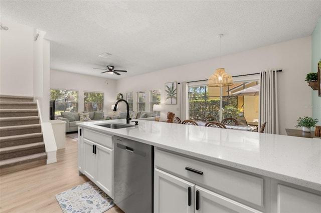 4722 Flagler Beach Way, Kissimmee, FL 34746 - kitchen featuring a textured ceiling, light wood-style floors, dishwasher, and a sink