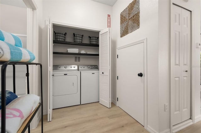 4722 Flagler Beach Way, Kissimmee, FL 34746 - clothes washing area featuring baseboards, washing machine and clothes dryer, laundry area, and light wood finished floors