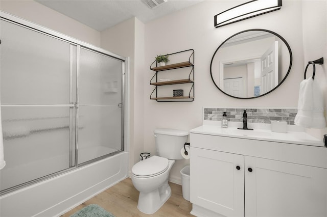 4722 Flagler Beach Way, Kissimmee, FL 34746 - bathroom featuring vanity, tasteful backsplash, toilet, enclosed tub / shower combo, and wood finished floors