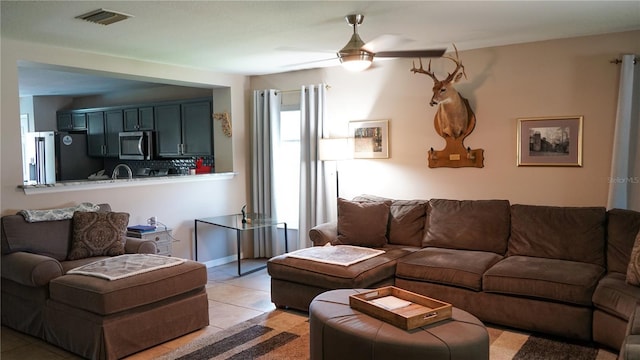 living area with visible vents, a ceiling fan, and light tile patterned floors