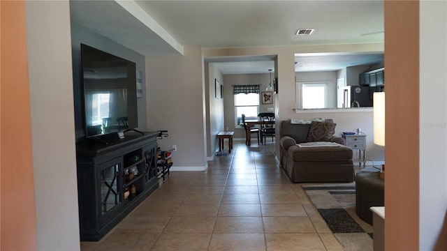 living area with baseboards, light tile patterned flooring, and visible vents