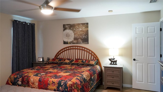 bedroom featuring a ceiling fan, light wood finished floors, and visible vents