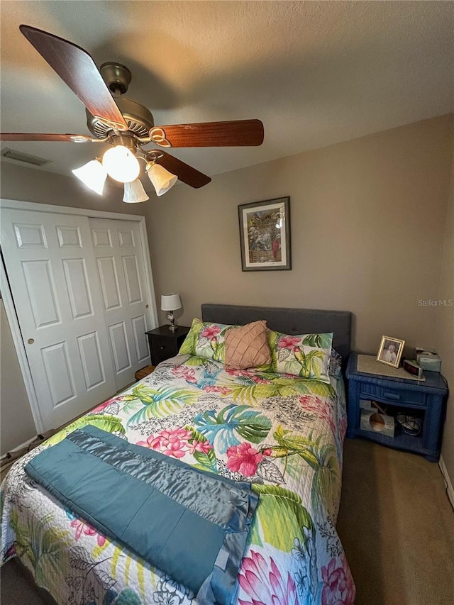 carpeted bedroom featuring a closet, ceiling fan, and visible vents