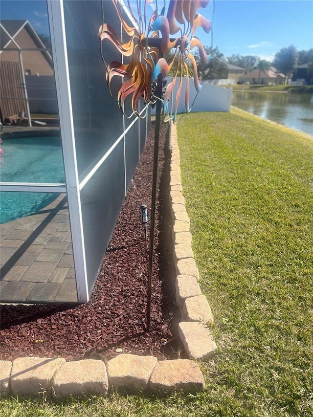 view of yard with a water view, fence, and an outdoor pool