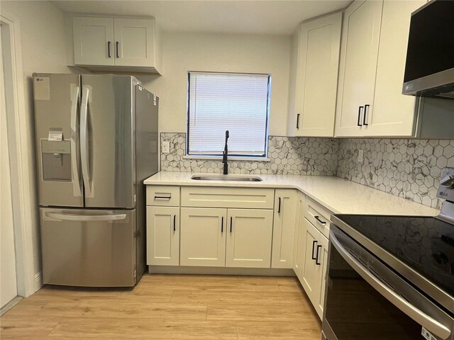3658 Briarcliff Way, Mims, FL 32754 - kitchen featuring appliances with stainless steel finishes, a sink, light wood finished floors, light countertops, and decorative backsplash