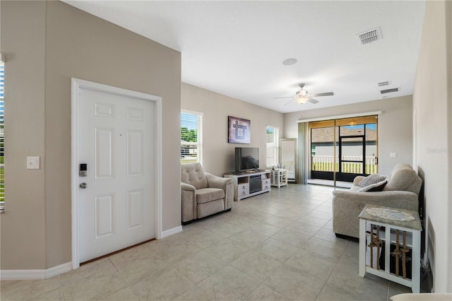13475 Crest Lake Dr, Hudson, FL 34669 - living room with baseboards, visible vents, light tile patterned floors, and ceiling fan