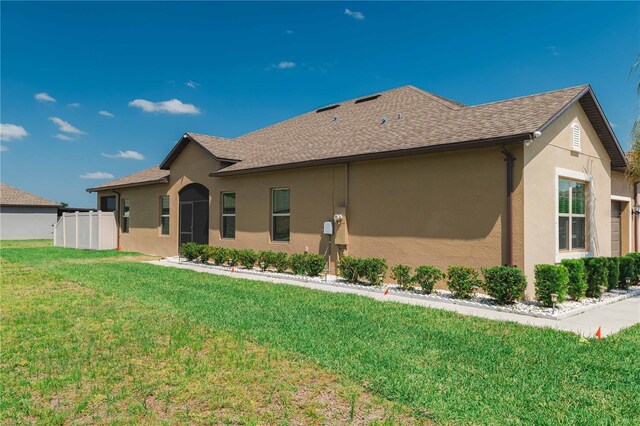 13475 Crest Lake Dr, Hudson, FL 34669 - back of property with stucco siding, fence, a yard, and a shingled roof