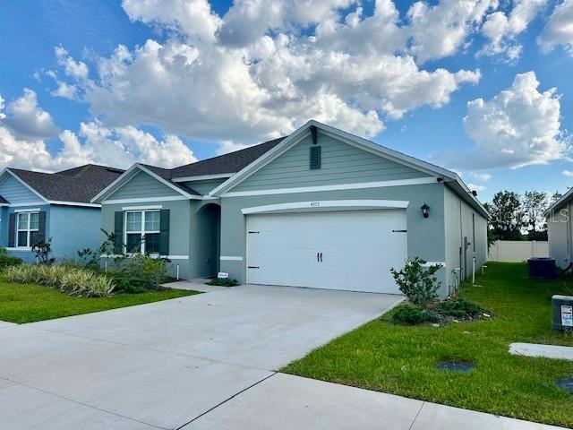 4373 Deleon St, Haines City, FL 33844 - ranch-style home with a garage, stucco siding, concrete driveway, and a front lawn