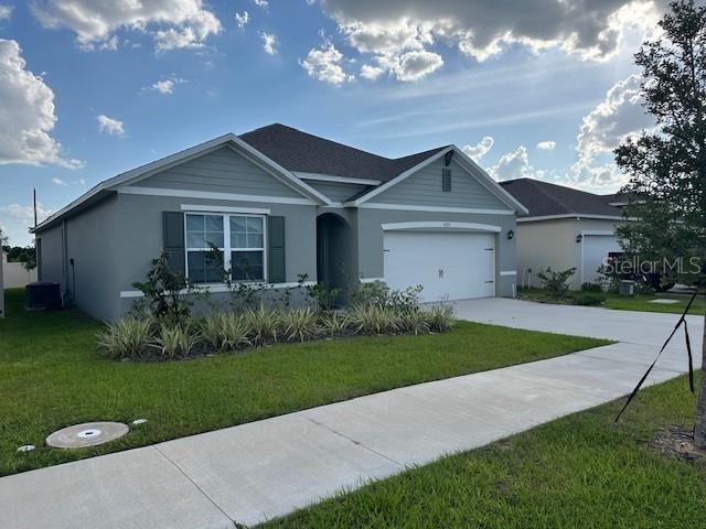 4373 Deleon St, Haines City, FL 33844 - ranch-style home featuring concrete driveway, an attached garage, stucco siding, and a front lawn
