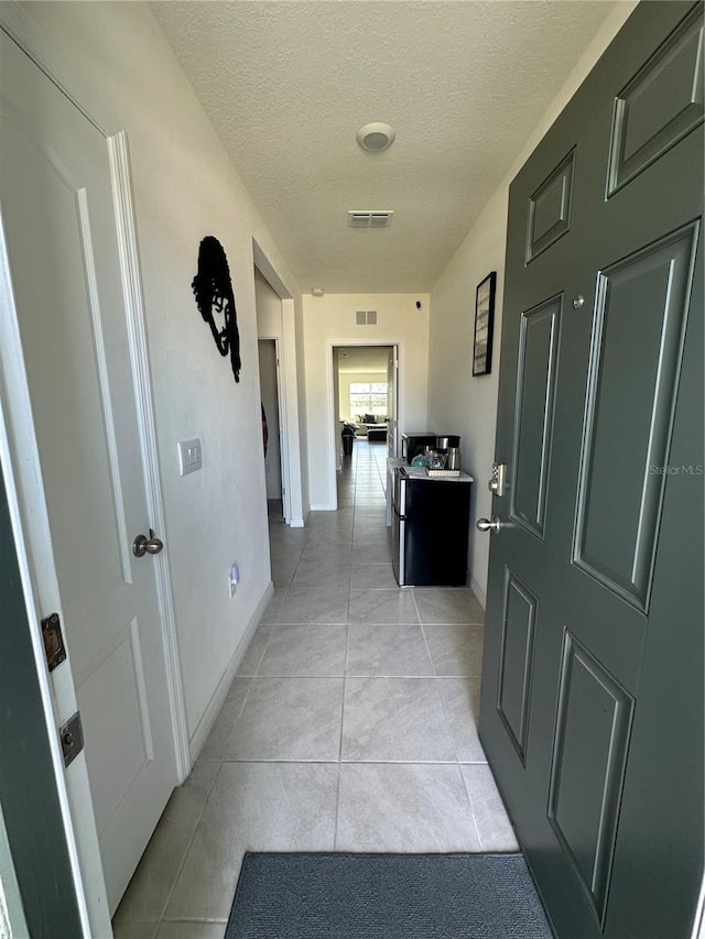 4373 Deleon St, Haines City, FL 33844 - corridor featuring a textured ceiling, baseboards, light tile patterned flooring, and visible vents