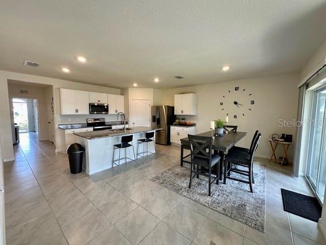 4373 Deleon St, Haines City, FL 33844 - dining area featuring a textured ceiling, visible vents, baseboards, recessed lighting, and light tile patterned flooring