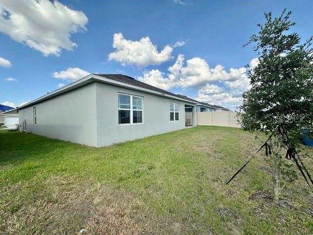 4373 Deleon St, Haines City, FL 33844 - view of property exterior with fence, stucco siding, and a yard