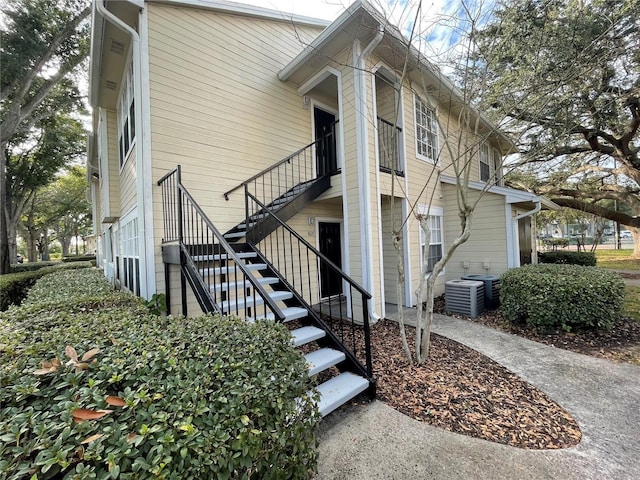 view of side of home with stairway and cooling unit