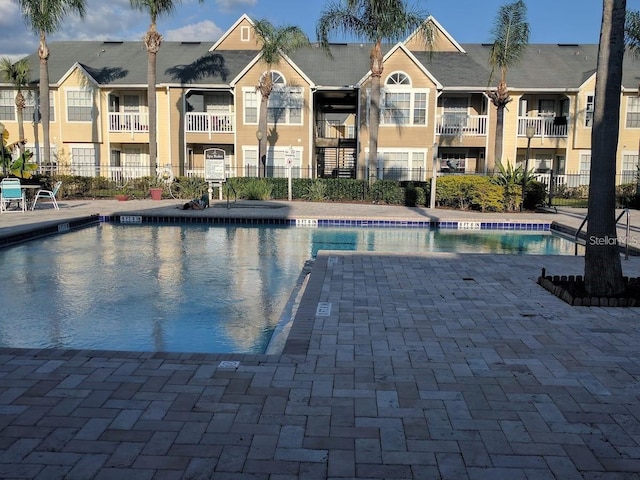 pool featuring fence and a patio
