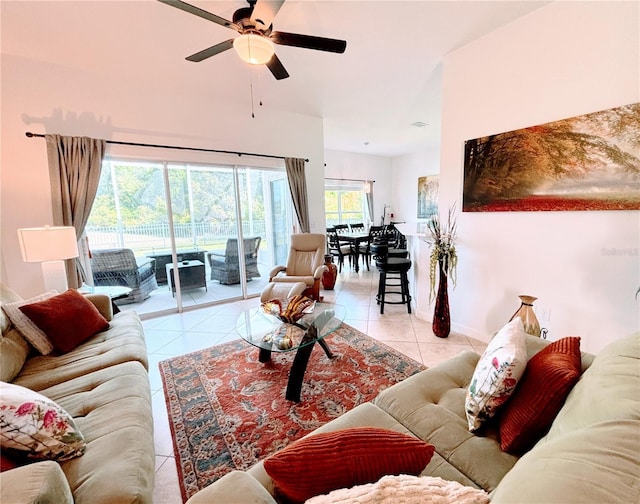 living area with baseboards, ceiling fan, and light tile patterned flooring