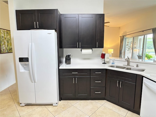 kitchen featuring white appliances, light tile patterned floors, a sink, and light countertops