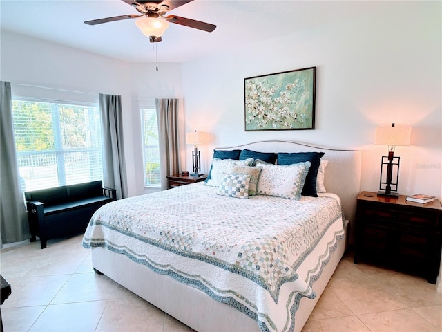 bedroom with a ceiling fan, light tile patterned floors, and multiple windows
