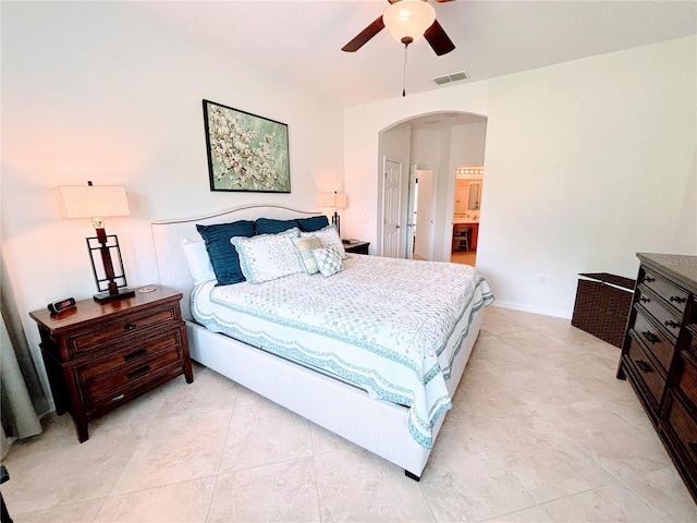 bedroom with visible vents, arched walkways, ceiling fan, and light tile patterned floors