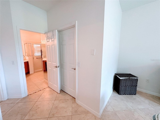 hallway with baseboards and light tile patterned floors