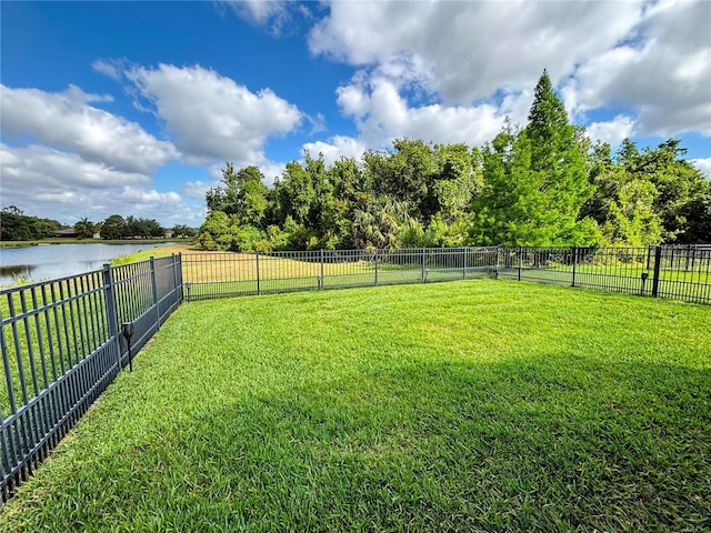 view of yard with a water view and a fenced backyard